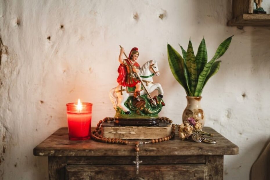 Oração de São Jorge: 5 orações de proteção, coragem e caminhos abertos 1 Imagem de São Jorge a cavalo num altar de madeira com vela vermelha, espada-de-são-jorge e terço